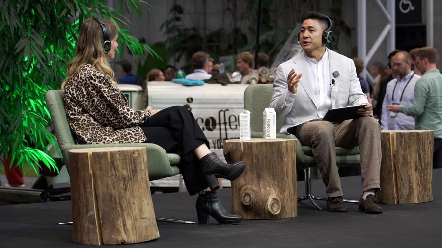 Bin Chen on stage in a panel talk with TikTok at TechBBQ Copenhagen 2025, wearing a headset microphone